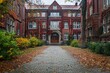 The brick walkway is lined with leaves and the building is red