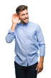 © Krakenimages.com - Young handsome man over isolated background smiling with hand over ear listening an hearing to rumor or gossip. Deafness concept.