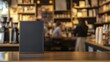 © cvetikmart - Blank sandwich board in a cafe, surrounded by shelves of books and customers enjoying their reading time. Empty sandwich board