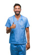 © Krakenimages.com - Adult hispanic doctor or surgeon man over isolated background doing happy thumbs up gesture with hand. Approving expression looking at the camera with showing success.