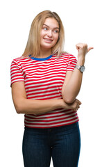 Young caucasian woman over isolated background smiling with happy face looking and pointing to the side with thumb up.