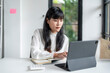 © Wasana - Focused asian businesswoman working on digital tablet in office