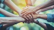 © Maria Mikhaylichenko - Diverse hands joining together in unity, symbolizing teamwork, collaboration, and community support against a vibrant, blurred natural background.