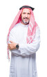 © Krakenimages.com - Senior arab man wearing keffiyeh over isolated background with serious expression on face. Simple and natural looking at the camera.