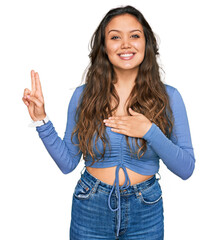 Young hispanic girl wearing casual clothes smiling swearing with hand on chest and fingers up, making a loyalty promise oath