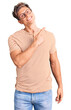 © Krakenimages.com - Young handsome man wearing casual clothes and glasses cheerful with a smile of face pointing with hand and finger up to the side with happy and natural expression on face