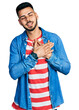 © Krakenimages.com - Young hispanic man with beard wearing casual denim jacket smiling with hands on chest with closed eyes and grateful gesture on face. health concept.