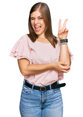 Beautiful caucasian woman wearing casual clothes smiling with happy face winking at the camera doing victory sign. number two.