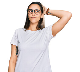 young hispanic woman wearing casual white t shirt confuse and wondering about question. uncertain wi