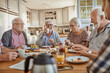 © Marko Geber - Diverse senior friends having breakfast together at home