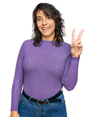 Sticker - Young hispanic woman wearing casual clothes showing and pointing up with fingers number two while smiling confident and happy.