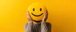 © lucas - Man holding a smiley face emoji in front of his face against yellow background, positive expression and joy