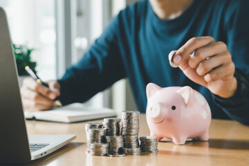 Wall Mural - Hand putting coins in a piggy bank for save money and Saving Money concept.