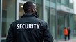 © Issaka - Security personnel monitoring the entrance of a modern building during the day