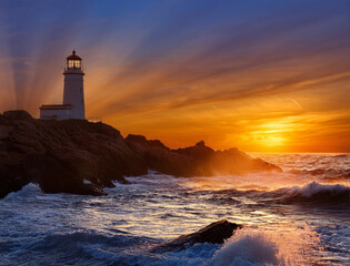 A lighthouse burning on the shore of the swirling sunset sea