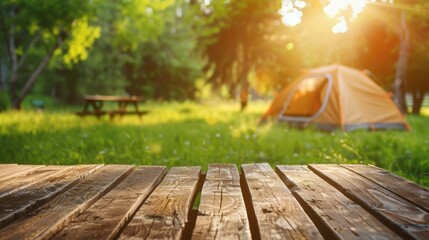 Poster - Wooden table top with blurred camping tent, grass field. Fresh and Relaxation theme for product display or visual layout with copy space.