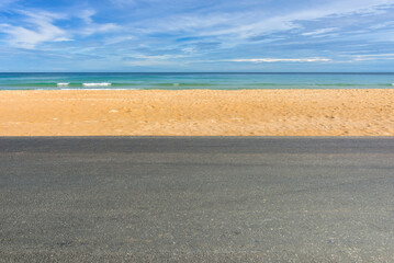 Wall Mural - Side view of asphalt road with beach on sea and beautiful blue sky.