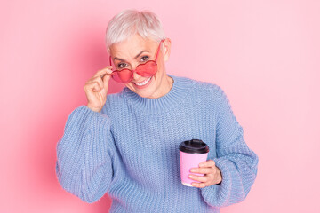 Poster - Photo portrait of pretty retired female hold coffee paper cup sunglass wear trendy blue knitwear outfit isolated on pink color background