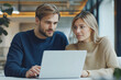 © Kowit - A man and a woman are looking at a laptop together
