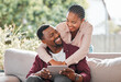 © Nina2024/peopleimages.com - Tablet, relax and black couple in home living room reading on sofa, social media or ebook. Tech, smile and happy people web scrolling, online browsing or streaming video, movie or film in lounge