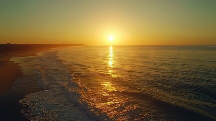 Wall Mural -   The sun sets over the ocean, with a beach in the foreground and another one in the background