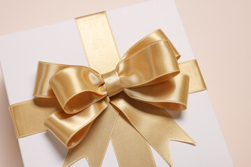 Wall Mural - Gift box with bow on beige background, closeup