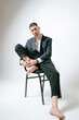 © Elina Leonova - Handsome man, fashion model sits on chair, barefoot