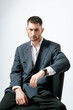 © Elina Leonova - Portrait of handsome man, fashion model. Sits on chair.