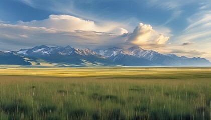 The vast grassland is intertwined with the distant mountains, and the clouds move slowly in the sky, presenting a tranquil and beautiful natural landscape.