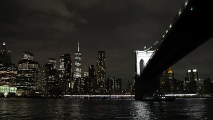 Wall Mural - view from boat passing under brooklyn bridge at night (east river sunset cruise) nyc downtown skyline famous landmark suspension bridge travel tourism new york city manhattan skyscrapers lit up harbor