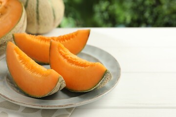 Canvas Print - Pieces of fresh Cantaloupe melon on white wooden table, closeup. Space for text