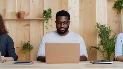 Professionals in a co-working space using laptops, digital tablets, and other tech tools, focusing on productivity