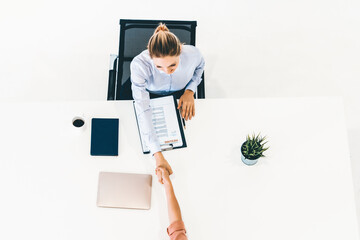 Two young business women in meeting at office table for job application and business agreement. Recruitment and human resources concept. uds