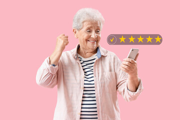 happy senior woman using mobile phone on pink background