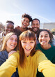© CarlosBarquero - Group of happy friends posing for a selfie on a spring day as they party together outdoors. Group of multicultural friends having a good time together on the weekend.