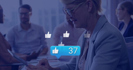 Poster - Image of media icons over caucasian businesswoman using smartphone over colleagues