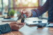 © Aleena - businessman handing over the car keys to his customer while sitting at an office desk