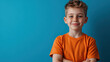 © khonkangrua - A smiling boy in an orange t-shirt stands confidently with arms crossed, showing a calm and self-assured expression.