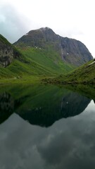 Wall Mural - a majestic mountain reflects in a serene lake, highlighting norway urke region natural beauty. its a