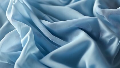 A piece of light blue fabric presents delicate folds and natural textures, creating a comfortable and soft atmosphere.