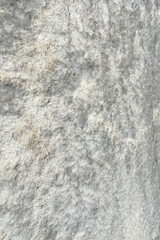 Gray Rock Formation with Marble Texture. Close-up view of a gray textured rock formation. The surface is uneven and contains a variety of patterns such as grooves, ridges, and small depressions. 