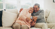 © peopleimages.com - Hug, funny and senior couple in house, love and care with retirement, happiness and bonding together. Apartment, embrace and mature woman with elderly man on couch, support and playful in lounge