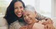 © Azee Jacobs/peopleimages.com - Hug, portrait and smile of old woman with daughter on sofa in living room of home for bonding or visit. Face, family or love with happy person and senior mother embracing in apartment together