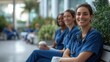 © ImagePulse - Healthcare workers sitting on a bench in the hospital courtyard, enjoying their coffee break, outdoor break, medical team rest