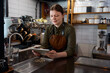 © Nomad_Soul - Female barista watching video on tablet taking break at workplace
