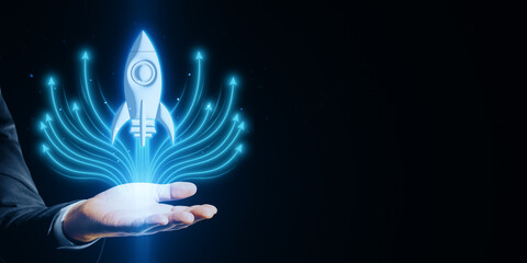 Poster - Businessman's hand holding a digital rocket launch symbol on a dark background.