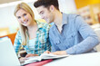 © ReeseBuyout3/peopleimages.com - Education, laptop and smile of happy friends in library at college or university campus for learning. Computer, development and study with student people at school desk for scholarship together