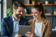 © Amir Bajric - Business colleagues sharing a laugh over a tablet. Male executive and young female employee