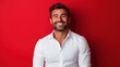 © Alpa - Adult man wearing white shirt standing and smiling friendly looking at camera on red background