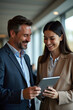 © Amir Bajric - Business colleagues sharing a laugh over a tablet. Male executive and young female employee